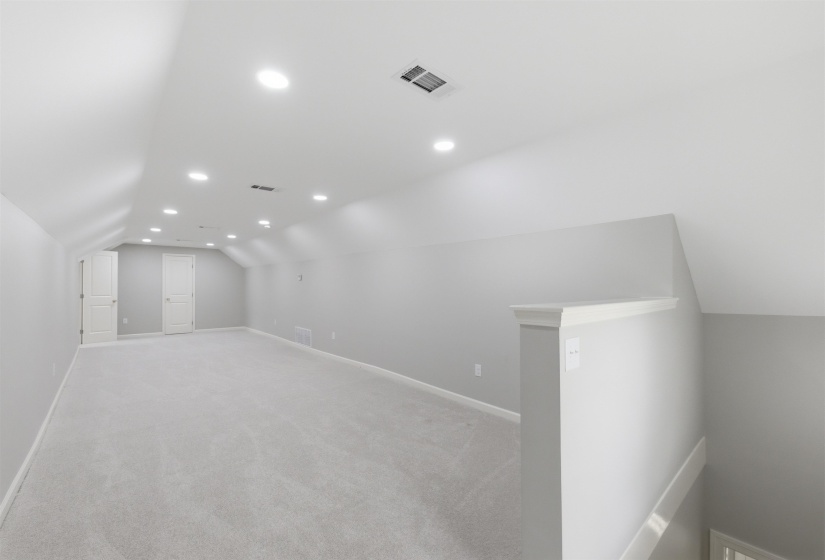 Bonus room featuring lofted ceiling, recessed lighting, and light colored carpet
