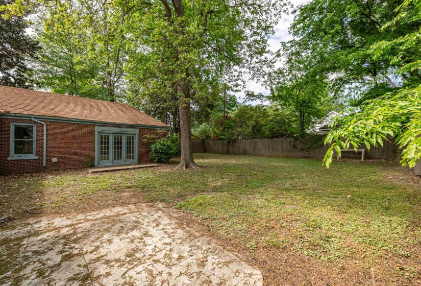 Fenced backyard featuring french doors