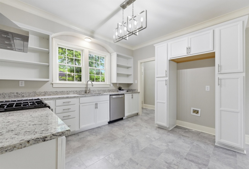 Kitchen featuring open shelves, white cabinets, hanging lights, crown molding, and light stone countertops