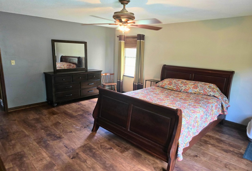 Bedroom with dark wood-style floors and ceiling fan