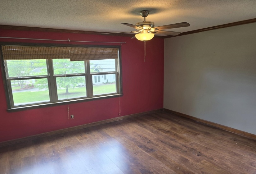 Unfurnished room featuring a textured ceiling, dark wood finished floors, and ceiling fan