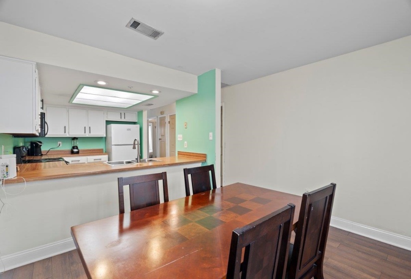 Dining area featuring dark wood finished floors and recessed lighting