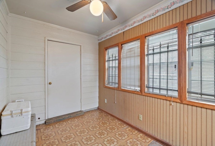 Entrance foyer featuring wood walls, light flooring, ornamental molding, and ceiling fan
