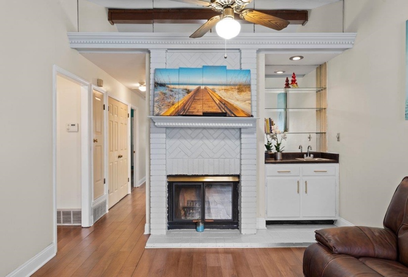 Living room featuring a fireplace, light wood-style flooring, and a ceiling fan