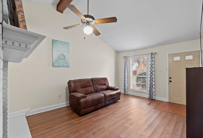 Living area featuring wood finished floors, a ceiling fan, and high vaulted ceiling