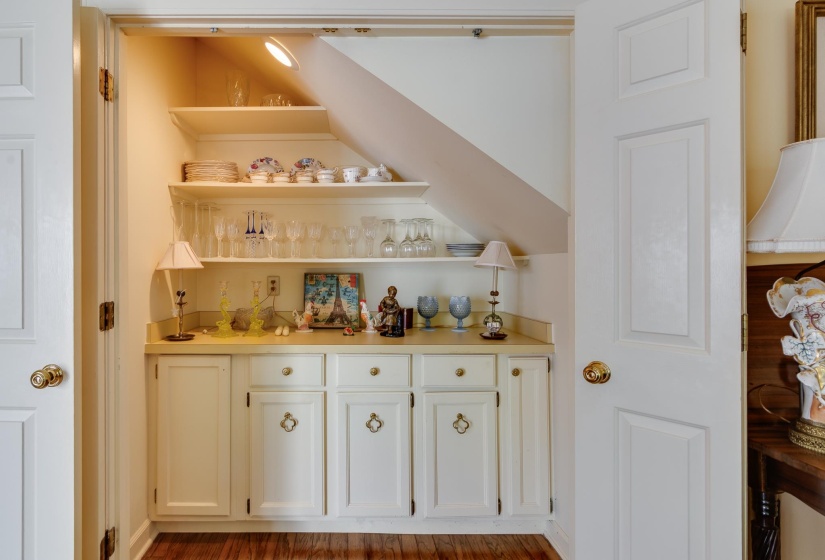 Bar with open shelves, white cabinets, light countertops, and dark wood-type flooring