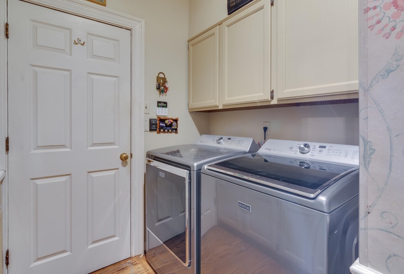 Laundry room with cabinet space, separate washer and dryer, and light wood finished floors
