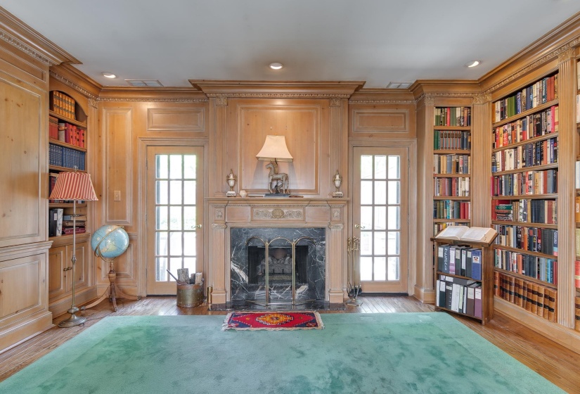 Living area featuring built in shelves, ornamental molding, light wood-style floors, a fireplace, and healthy amount of natural light