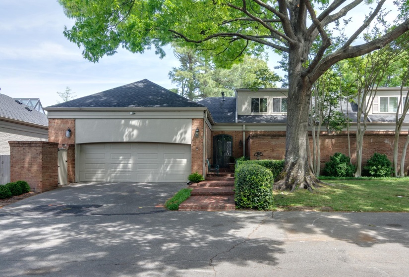 View of front of house featuring brick siding, roof with shingles, an attached garage, driveway, and a front yard
