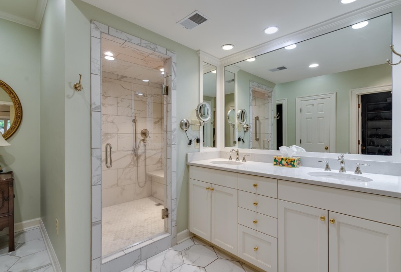 Full bathroom with double vanity, light marble finish flooring, a marble finish shower, and recessed lighting