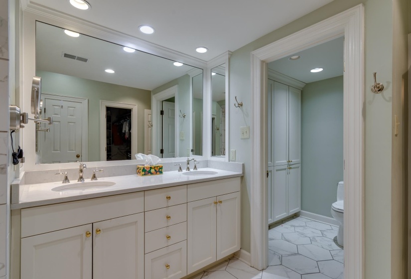 Bathroom with double vanity, a spacious closet, and recessed lighting