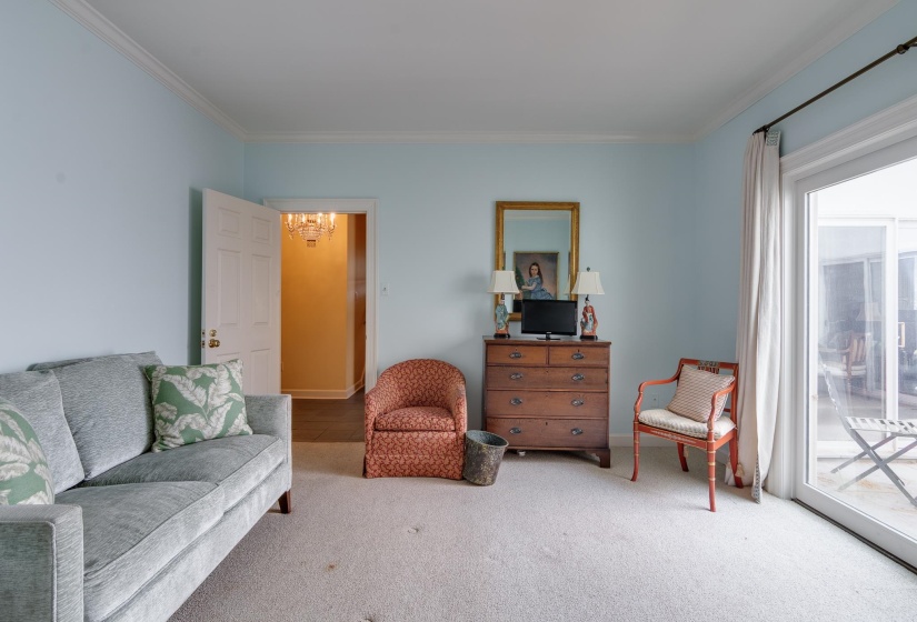 Living area featuring carpet, ornamental molding, and a chandelier