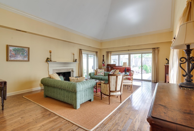 Living area with a fireplace, light wood-type flooring, and lofted ceiling