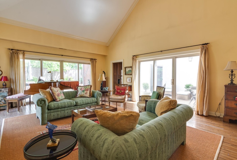 Living area featuring hardwood / wood-style flooring, vaulted ceiling, and crown molding