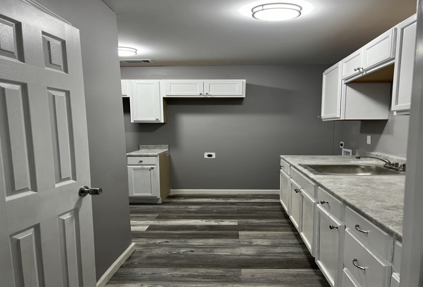 Kitchen featuring light countertops, white cabinetry, and dark wood-style flooring