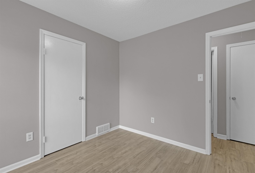 Unfurnished bedroom with light wood-style flooring and a textured ceiling