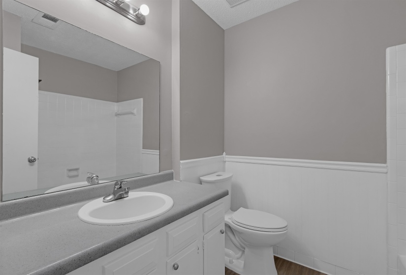 Bathroom featuring vanity, a shower, dark wood-style flooring, and a textured ceiling