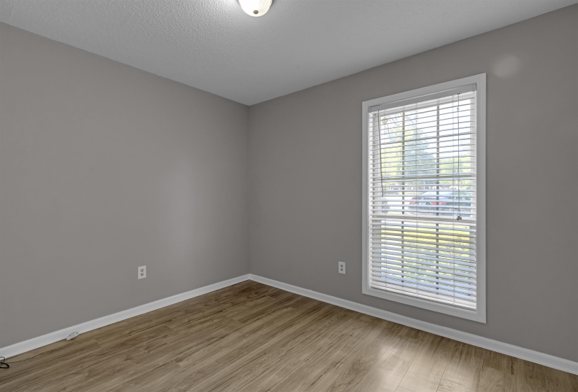 Empty room featuring light wood-style floors and a textured ceiling