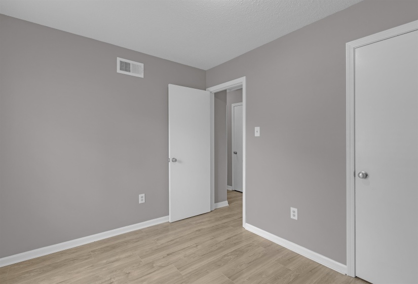 Unfurnished bedroom featuring light wood finished floors and baseboards