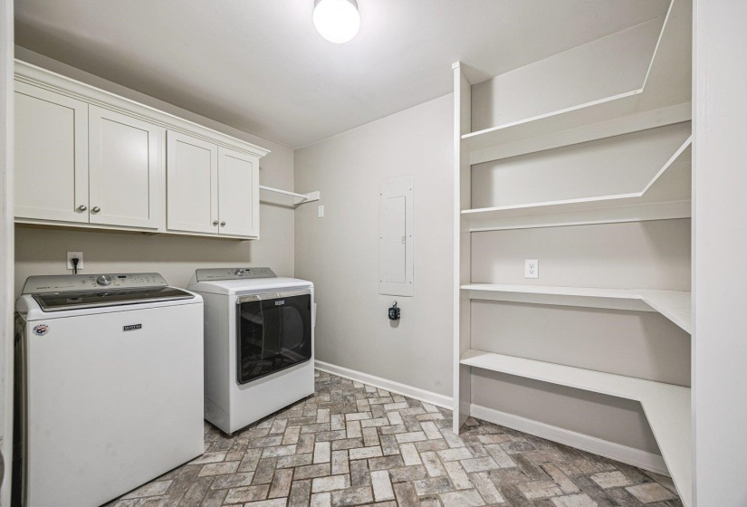 Laundry area with cabinet space, independent washer and dryer, and electric panel