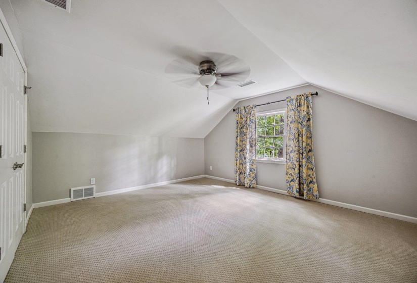 Additional living space with a ceiling fan and carpet floors