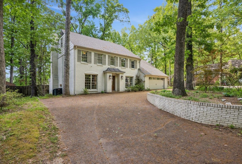 Colonial home featuring brick siding, driveway, and an attached garage