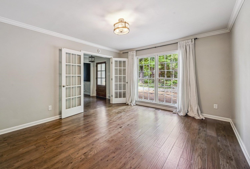 Unfurnished room with crown molding, french doors, and dark wood-style flooring