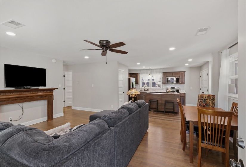 Living room with light wood-type flooring, ceiling fan, and recessed lighting