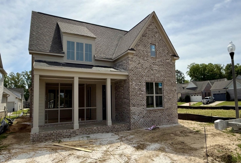 Back of house featuring roof with shingles, brick siding, and a patio area