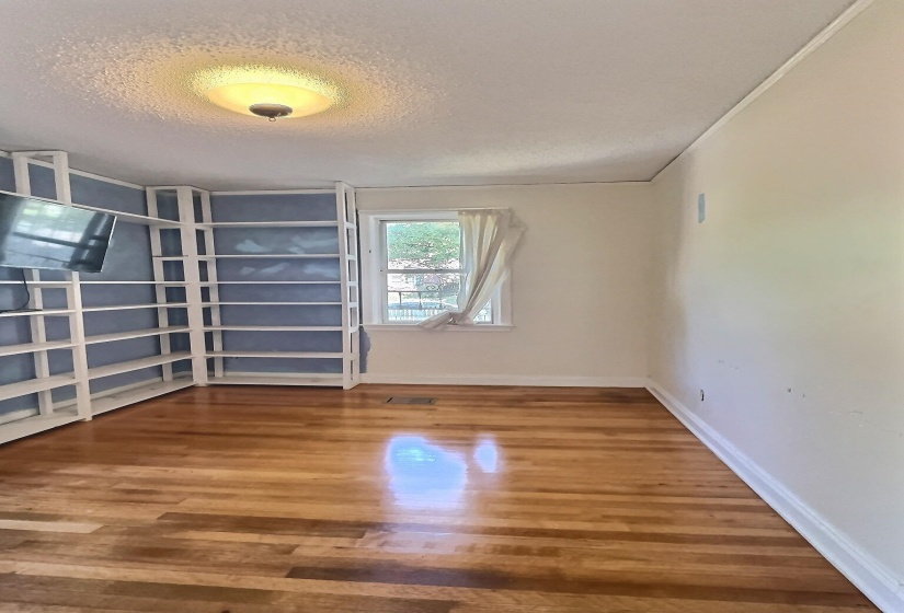 Unfurnished room with a textured ceiling and wood finished floors
