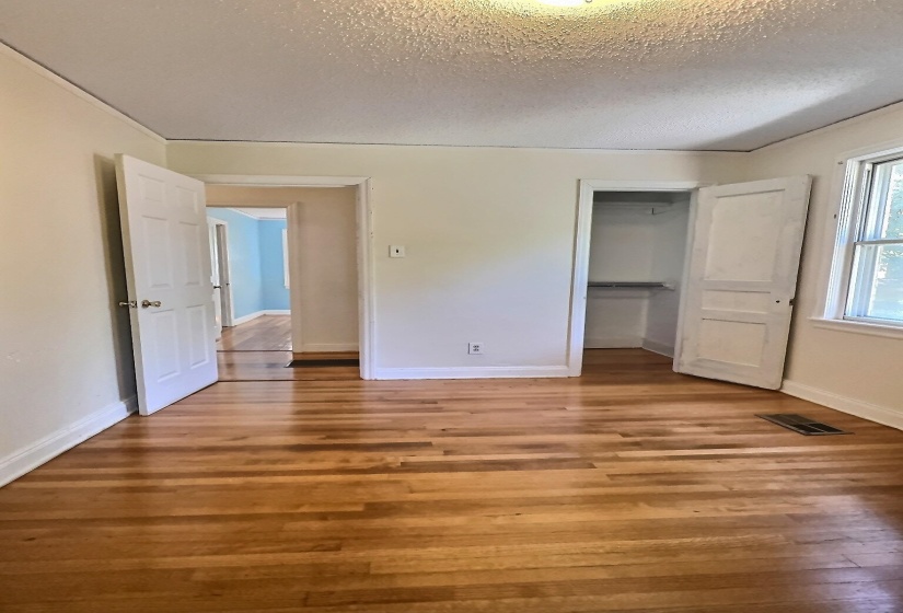 Unfurnished bedroom featuring a closet, light wood finished floors, and a textured ceiling