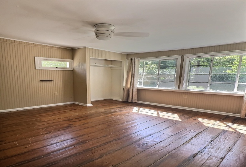 Unfurnished bedroom featuring a closet, ceiling fan, and dark wood-type flooring