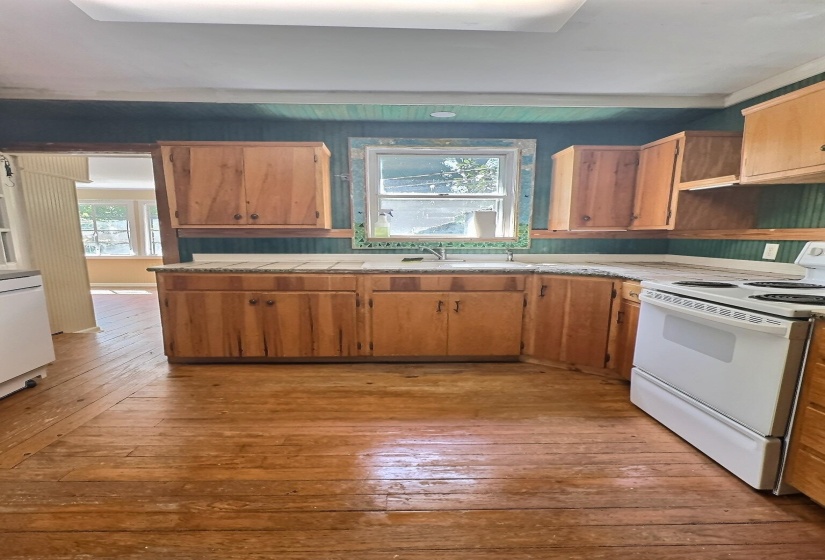 Kitchen featuring electric stove, light countertops, plenty of natural light, and light wood-type flooring
