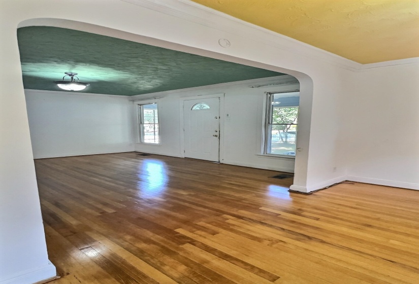 Entryway featuring arched walkways, hardwood / wood-style flooring, ornamental molding, and a textured ceiling