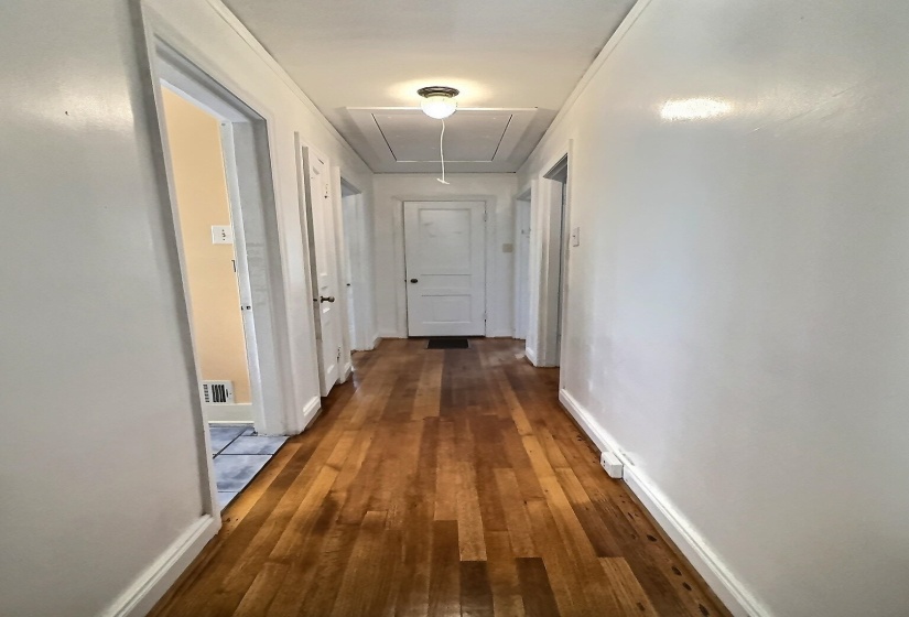 Hall with dark wood-style floors and attic access