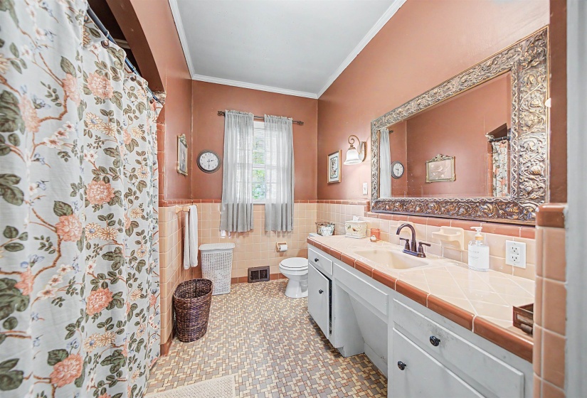 Bathroom with wainscoting, vanity, crown molding, a shower with shower curtain, and tile walls