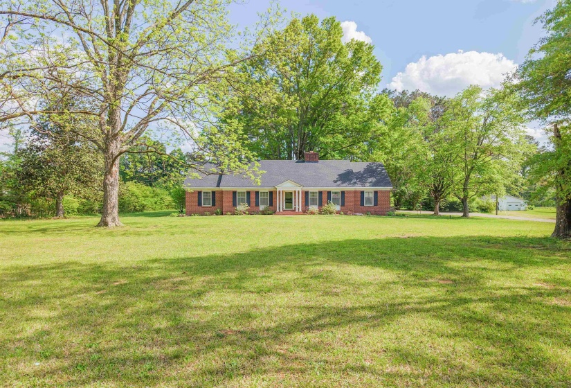Single story home with a front lawn, a chimney, and brick siding