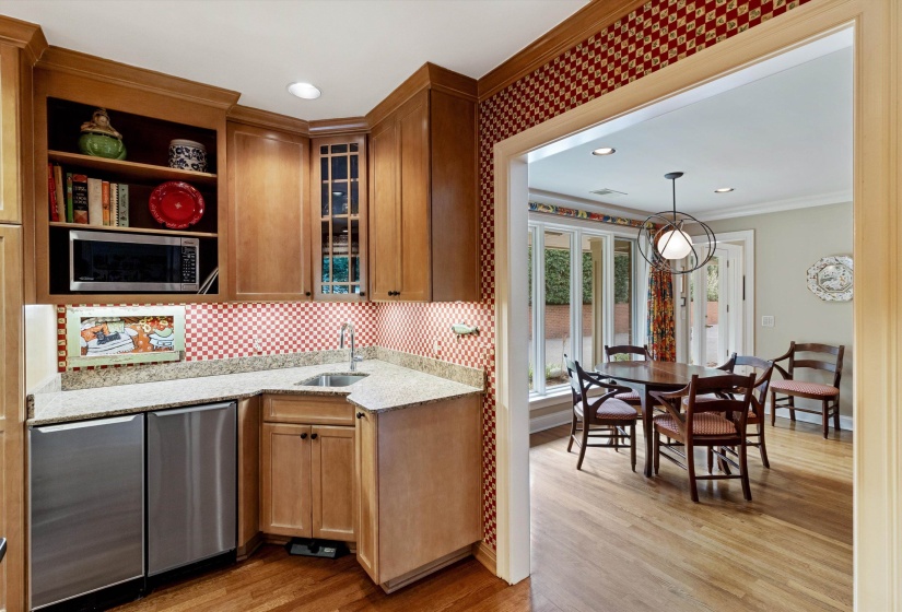 Butler’s Pantry Center in the Thoughtfully Designed Kitchen Featuring a Granite Serving Counter and Convenient Prep Sink near the Breakfast Area.
