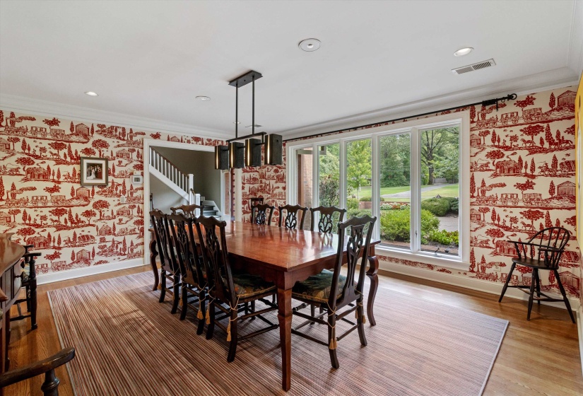 Spacious Dining Room With Custom Light Fixture,  Gorgeous Hardwood, and Wall of Windows Overlooking the Front Grounds.