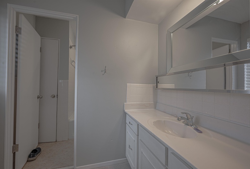Bathroom with vanity, a bathing tub, and backsplash