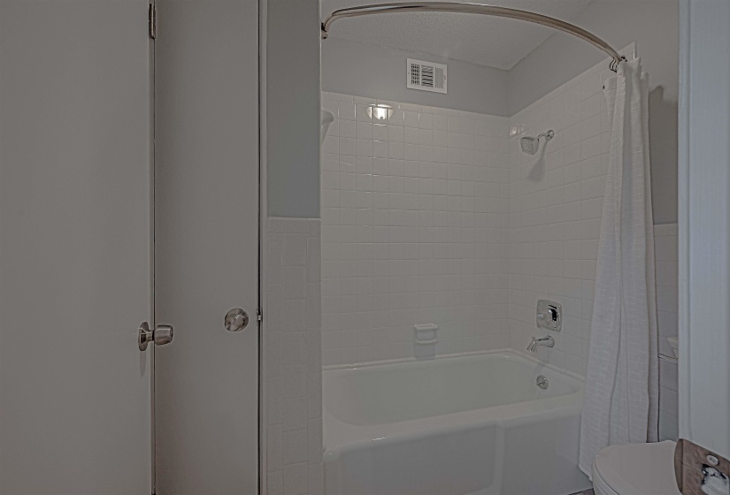 Bathroom with toilet and shower / bath combo with shower curtain