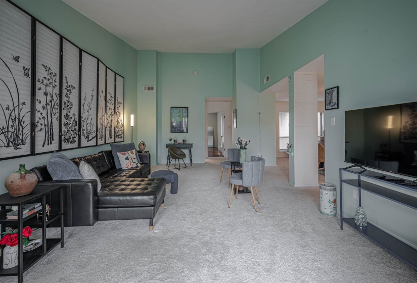 Carpeted living room featuring a towering ceiling