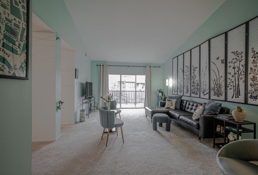 Living room with light carpet and high vaulted ceiling