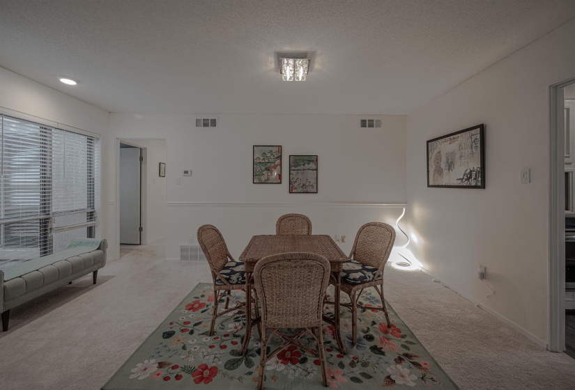 Carpeted dining space featuring a textured ceiling