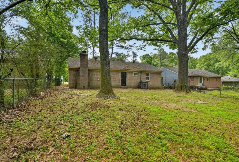 Back of property featuring a chimney and brick siding