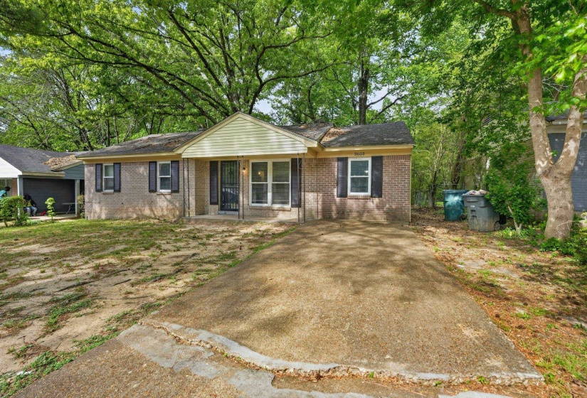 Single story home with brick siding, a porch, and roof with shingles