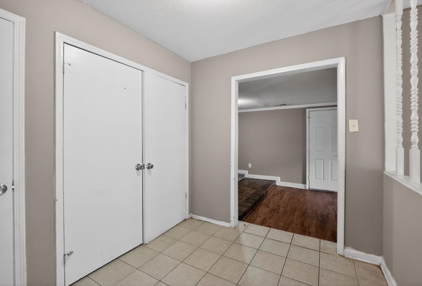 Unfurnished bedroom featuring a textured ceiling, light tile patterned floors, and a closet