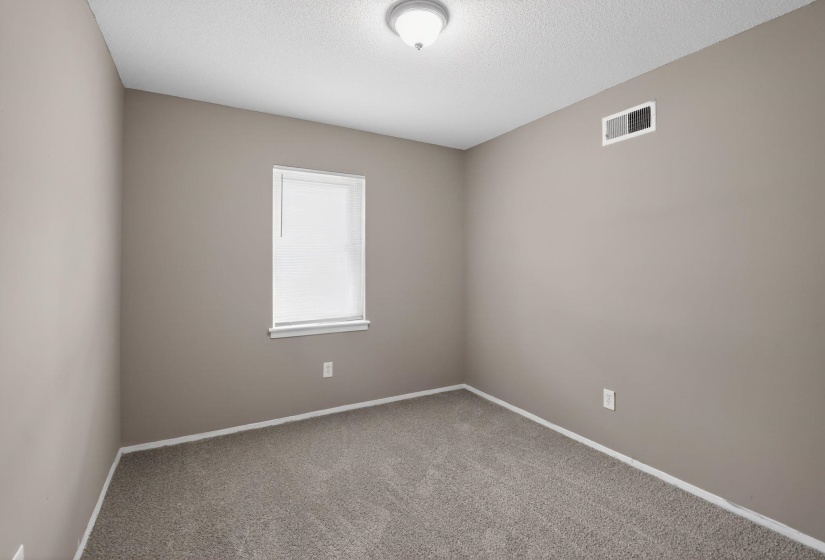 Empty room with carpet flooring and a textured ceiling