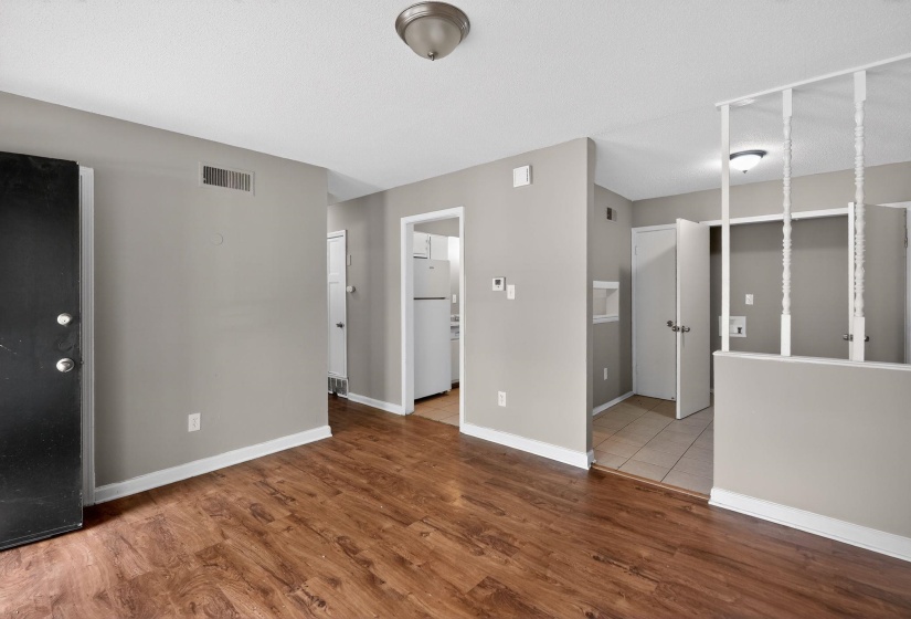 Unfurnished living room with wood finished floors and baseboards