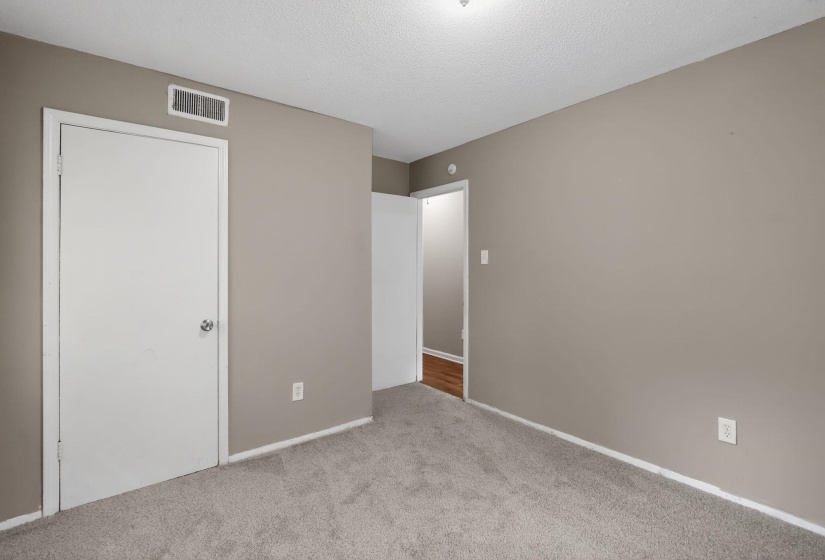 Unfurnished bedroom featuring light carpet and a textured ceiling